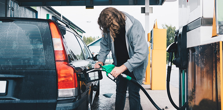 Person refueling at a gas station.