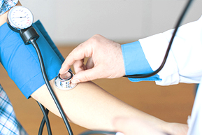 Läkare mäter blodtryck på patient, detalj.